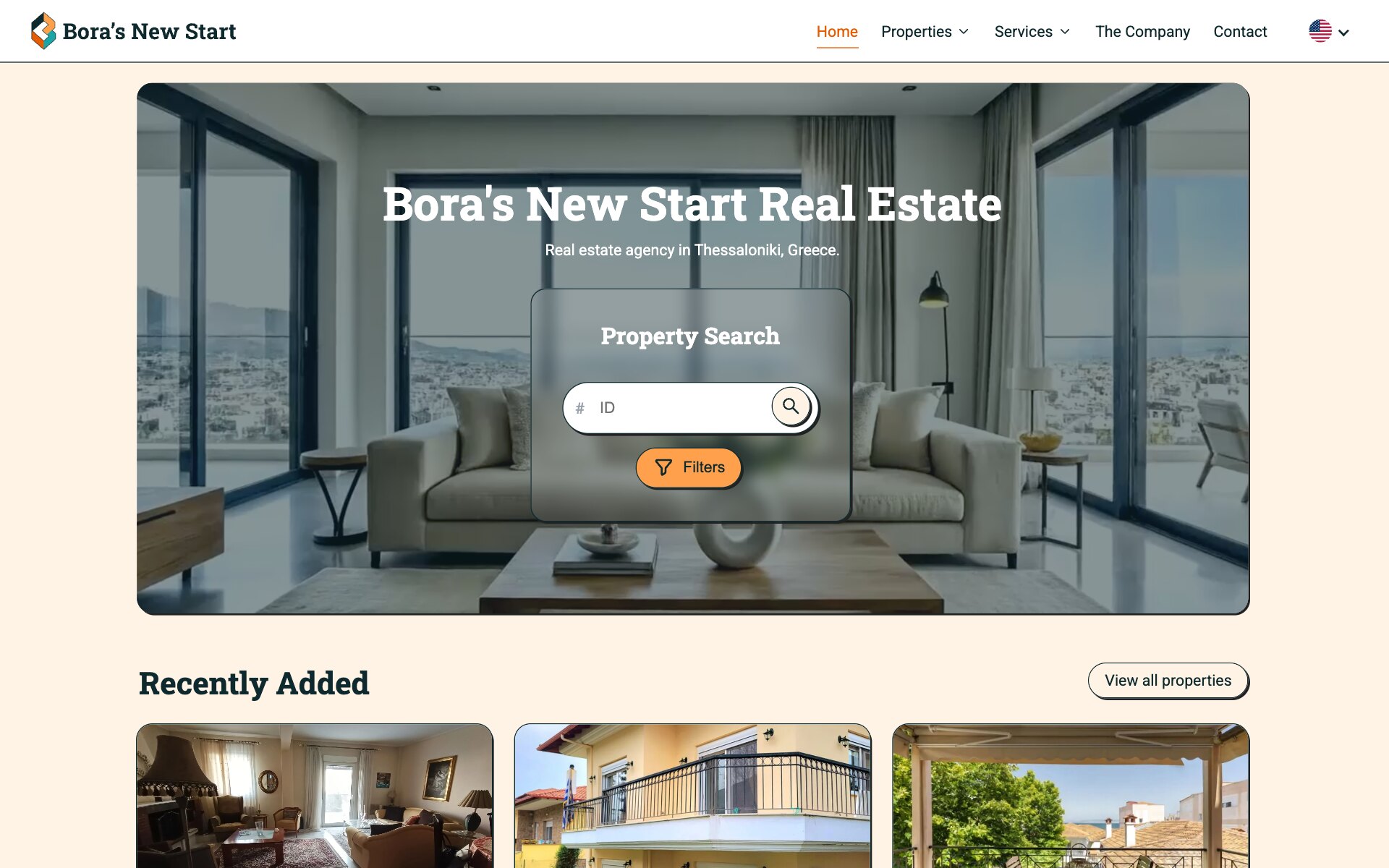 The Bora's New Start home page in English: the logo, the menu Home, Properties, Services, The Company and Contact, and a language picker showing a US flag; a rounded photograph of a bright living room with grey sofas and floor-to-ceiling windows over a city carries the headline "Bora's New Start Real Estate", the line "Real estate agency in Thessaloniki, Greece." and a frosted "Property Search" panel with an ID field, a search button and an orange "Filters" button; below come the heading "Recently Added", a "View all properties" button and the tops of three listing photographs.