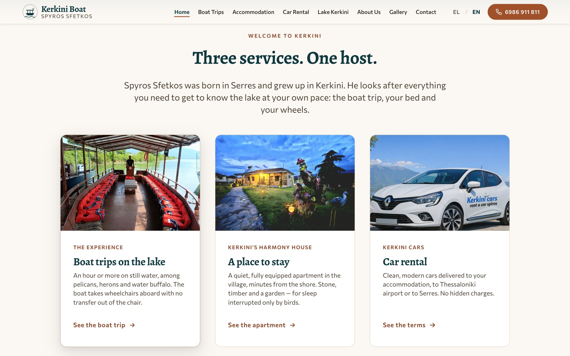 “Three services. One host.”板块:一段介绍 Spyros Sfetkos 的简短文字和三张卡片,第一张在鼠标悬停下微微抬起并带有阴影。卡片照片分别是:木顶棚下摆满红色救生衣的船甲板、黄昏时分花园亮灯并摆着木雕鸟的民宿,以及停在群山前的一辆白色 Kerkini Cars 租赁车;每张卡片都有标签、标题(Boat trips on the lake、A place to stay、Car rental)、简短说明和链接。
