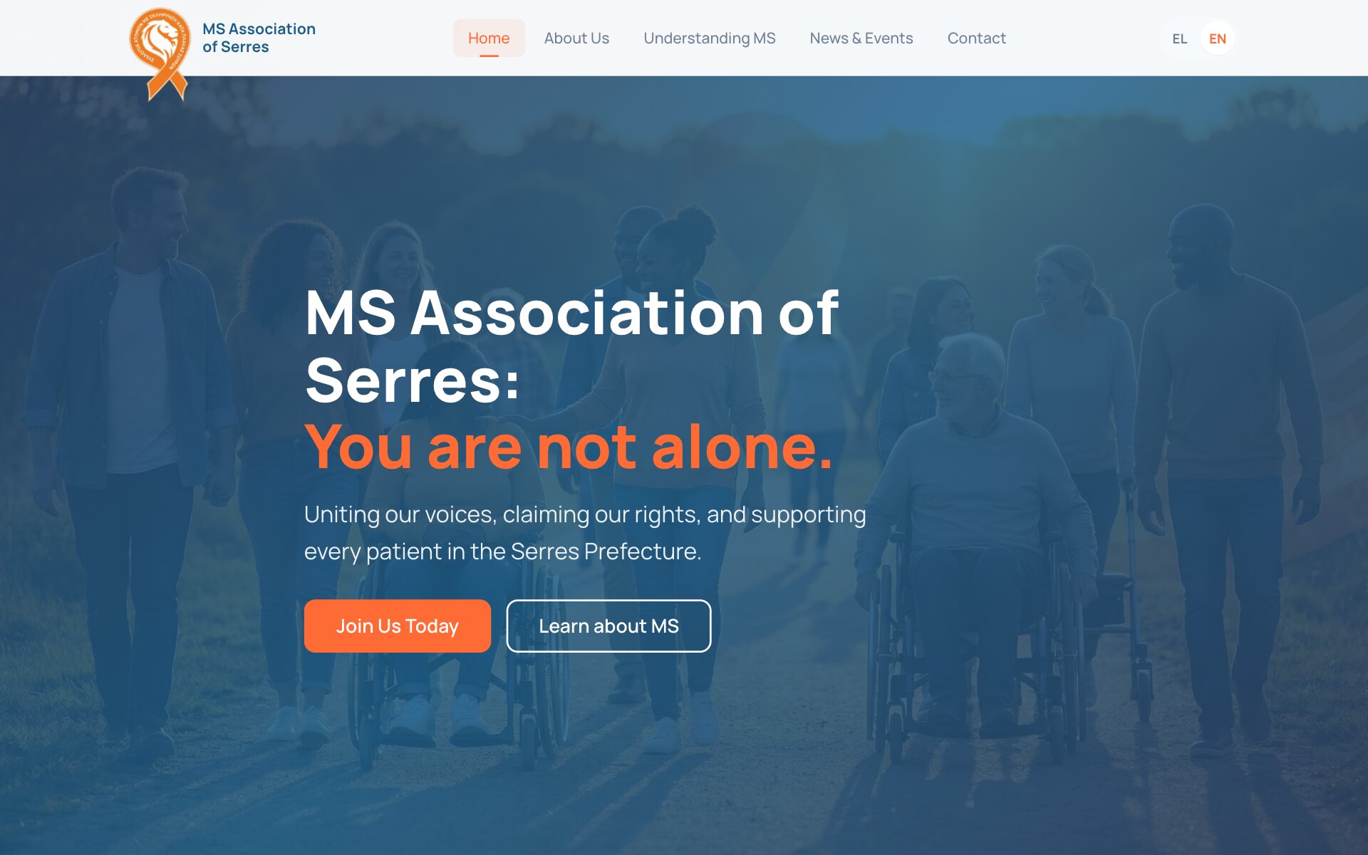 The MS Association of Serres home page in English: the logo, an orange ribbon with a lion's head, and the menu Home, About Us, Understanding MS, News & Events and Contact, with Home highlighted and EN selected; over a blue-tinted photograph of a group of people walking along a path outdoors, some of them in wheelchairs, the headline "MS Association of Serres: You are not alone.", its second line in orange, the line "Uniting our voices, claiming our rights, and supporting every patient in the Serres Prefecture." and an orange "Join Us Today" button beside an outlined "Learn about MS" button.