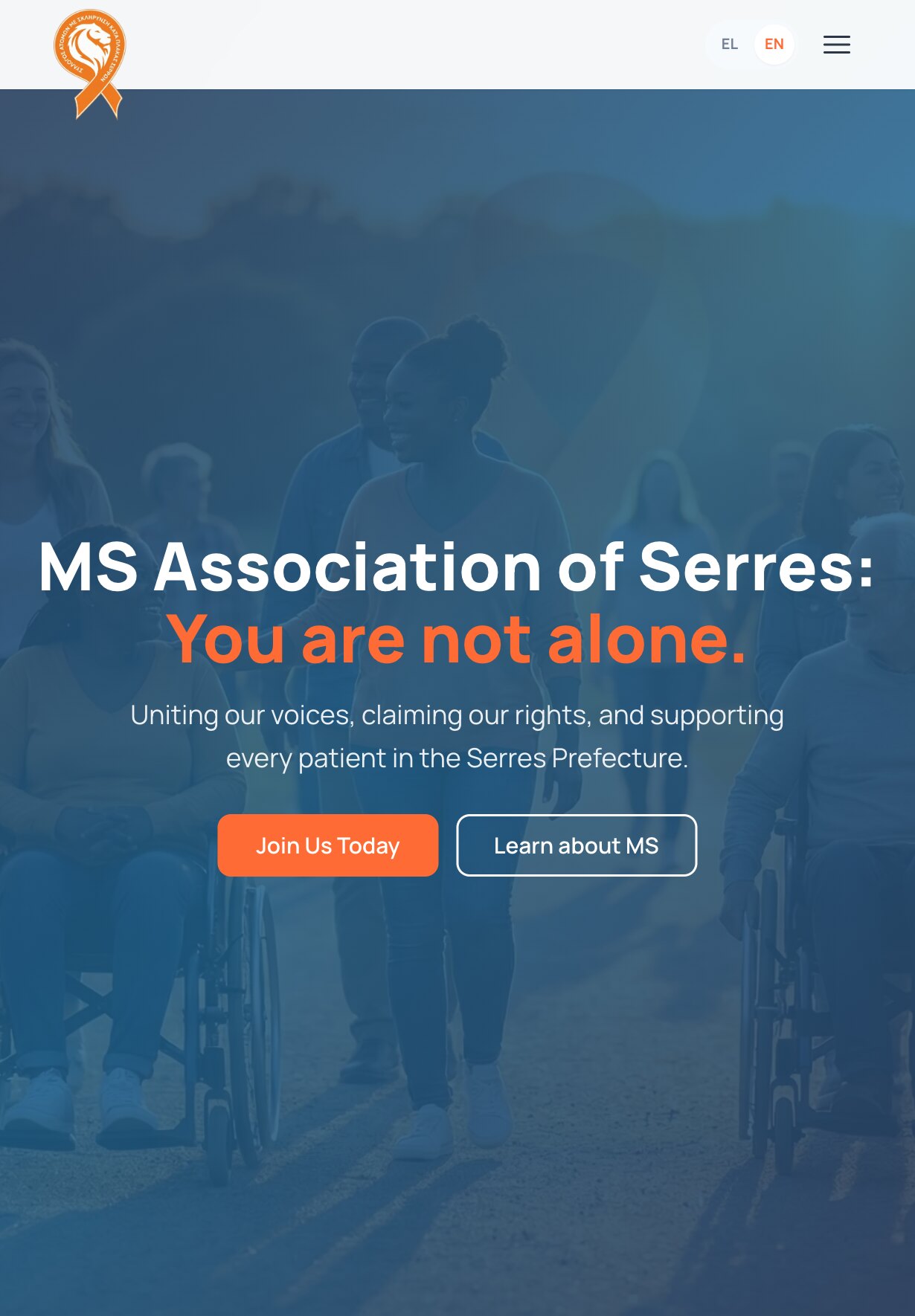 The home page on a tablet: the ribbon logo, the EL/EN switch and a menu button above the blue-tinted photograph of people walking outdoors, some in wheelchairs; centred on it, the headline "MS Association of Serres: You are not alone." on two lines, the supporting line, and the "Join Us Today" and "Learn about MS" buttons side by side.
