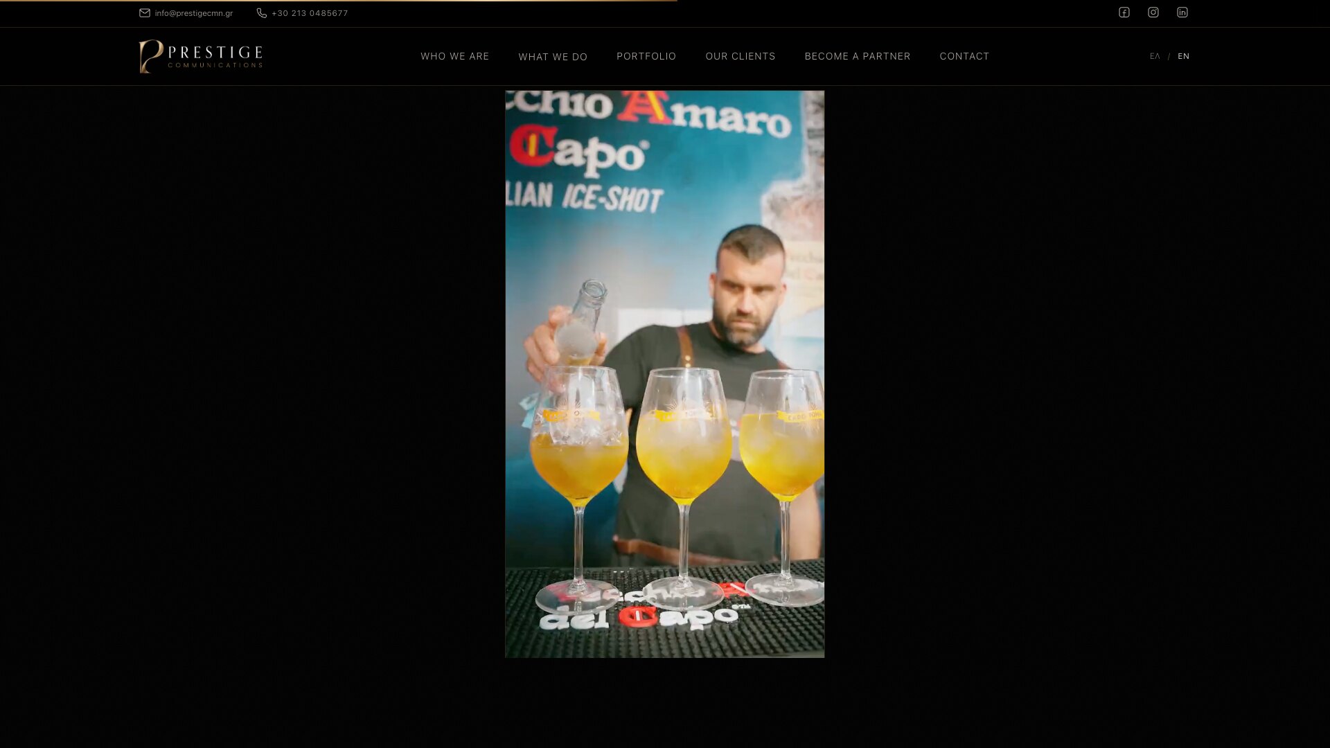 黑色页面中央的竖幅视频画面：吧台后，一名男子在 Vecchio Amaro del Capo 的横幅前，往三只装着橙色饮品的高脚杯里倒酒。