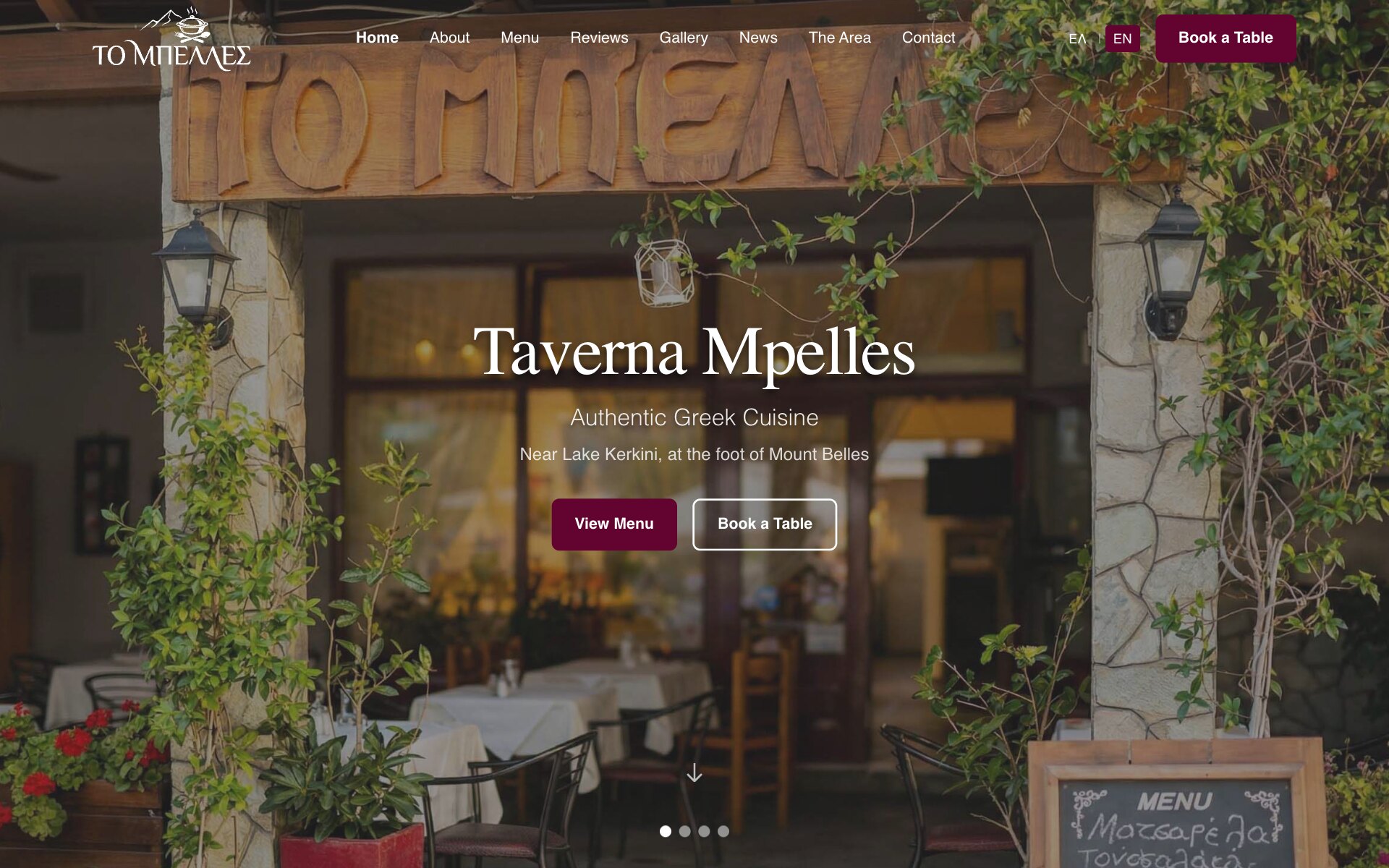 The Taverna Mpelles home page: the ΤΟ ΜΠΕΛΛΕΣ logo, a menu of Home, About, Menu, Reviews, Gallery, News, The Area and Contact, an ΕΛ | EN switch and a "Book a Table" button, over a photograph of the taverna's entrance — a carved wooden sign reading "ΤΟ ΜΠΕΛΛΕΣ" on stone pillars with lanterns and climbing plants, tables with white cloths inside and a chalkboard menu in the corner; in the middle the heading "Taverna Mpelles", the lines "Authentic Greek Cuisine" and "Near Lake Kerkini, at the foot of Mount Belles", a "View Menu" button and an outlined "Book a Table" button, with four slide dots below.